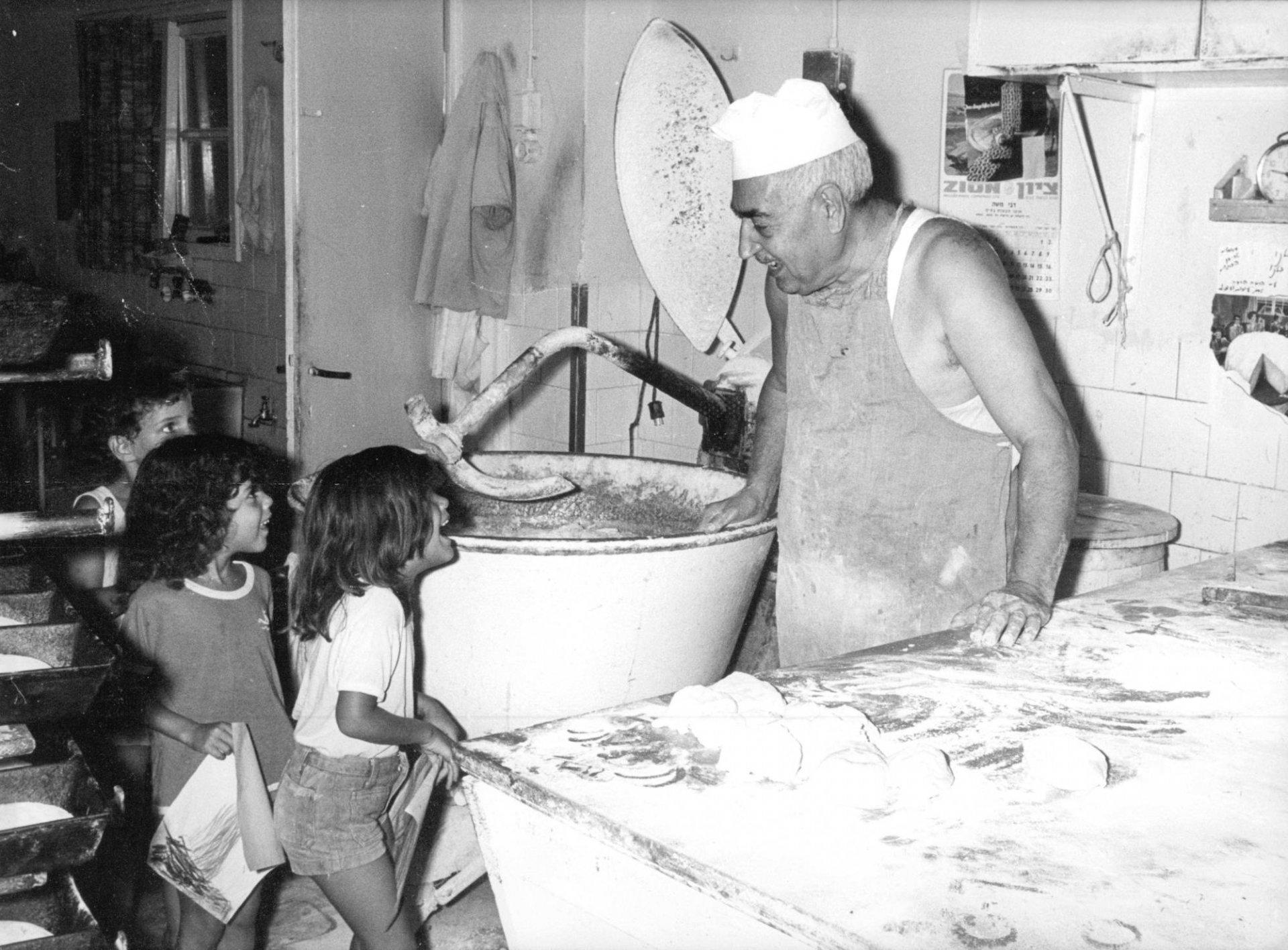 סלים חייט במאפיה ליד מערבל הבצק עם